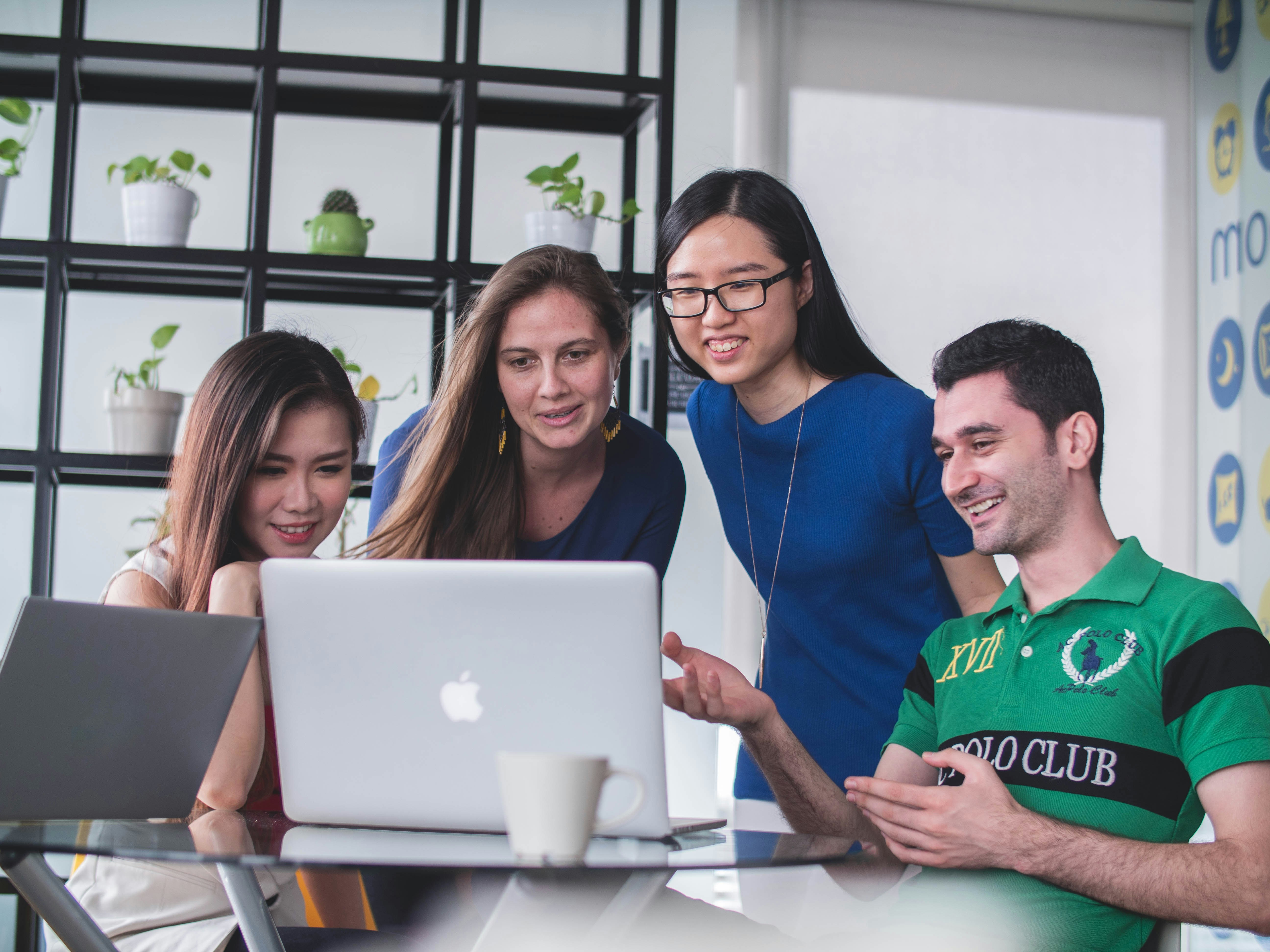 Young people collaborating around a laptop